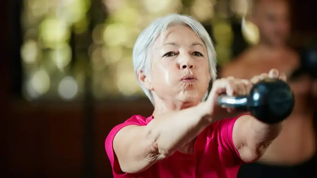 Toning Arms After 60: Empowering Womens Fitness Through Effective Weight Training 1 Older woman doing weight training Walthams Cross to help her strength and longevity