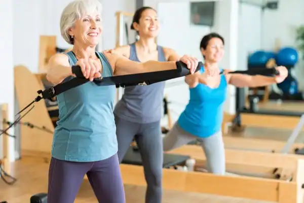 Toning Arms After 60: Empowering Womens Fitness Through Effective Weight Training 2 older woman doing weight training Walthams Cross and resistance in the gym to tone upper arms