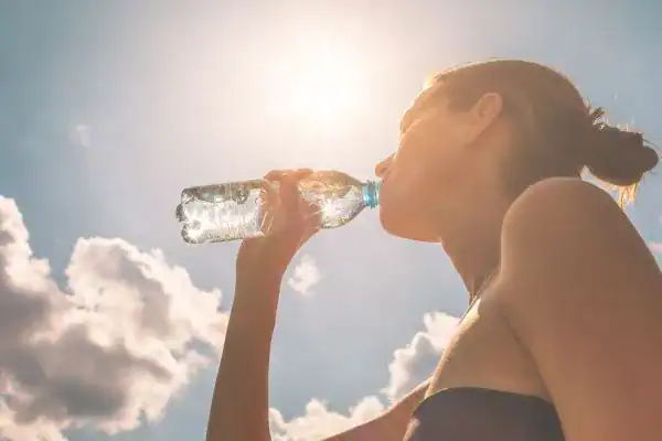 Hydration: The Secret Ingredient for a Toned Stomach and Enhanced Fitness 3 Image of woman drinking water to hydrate Walthams Cross after run.