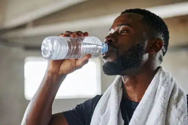 Hydration: The Secret Ingredient for a Toned Stomach and Enhanced Fitness 1 Image of man drinking water to improve hydration Walthams Cross after work out.